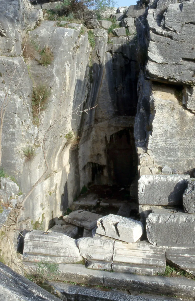 Entrance to the burial chamber inside the rock-cut base, with fallen marble blocks in front