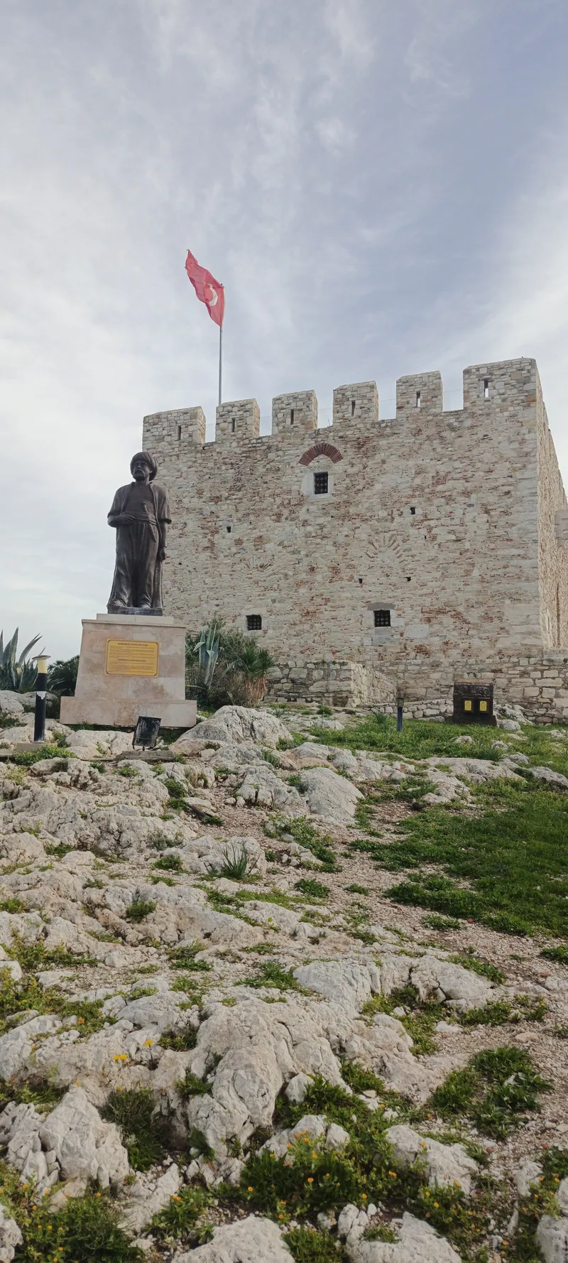 Adanın ortasındaki kare planlı, mazgallı iç kale; önünde Barbaros Hayreddin Paşa anıtı